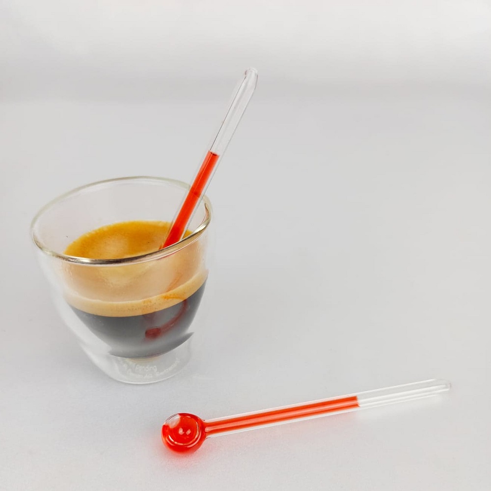 cuillère à café rouge dans tasse bodum double paroi gros plan
